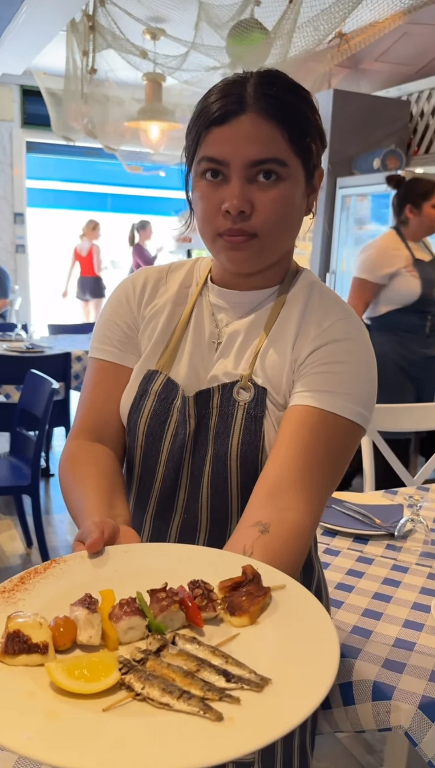 Team member serving a seafood tasting plate